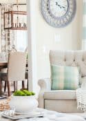 neutral accent chair with pillow and throw