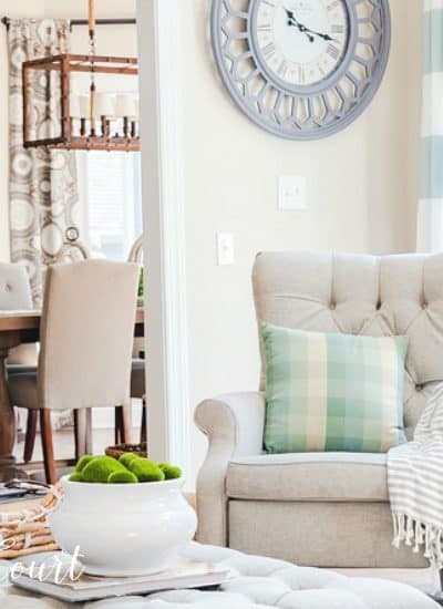 neutral accent chair with pillow and throw