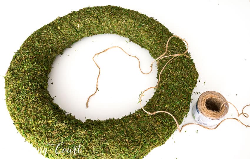 Wrapping twine around the moss covered wreath.