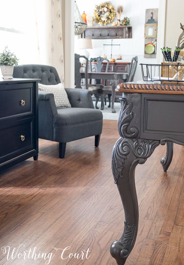 The ornate legs of the office desk that have been painted.