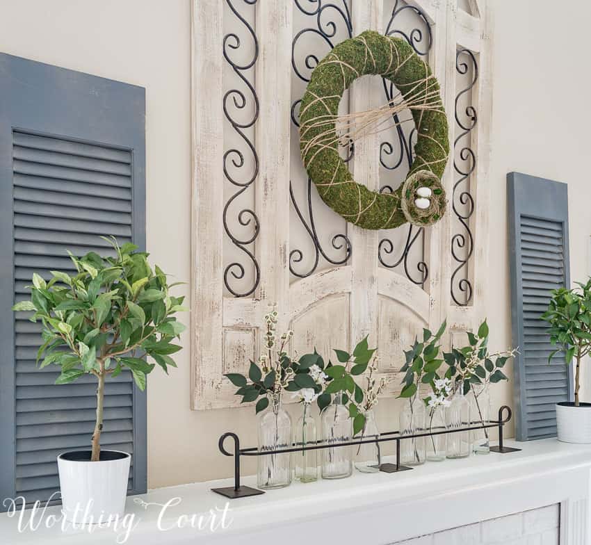 Spring mantle decor featuring lighted Easter garlands, pastel tones, and modern accents for a seasonal refresh