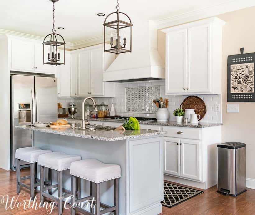 Kitchen with white shaker cabinets and gray island showing negative space design