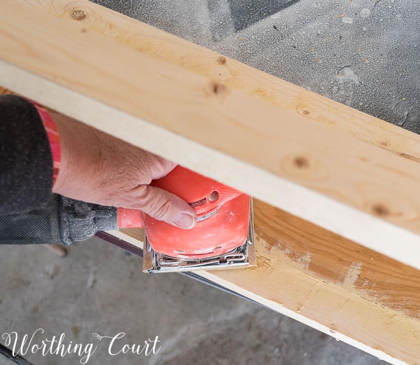  Using a hand sander on the base.