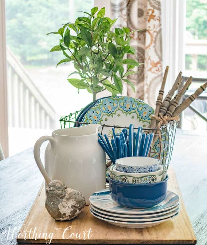 centerpiece with blue white and green dishes on a breadboard