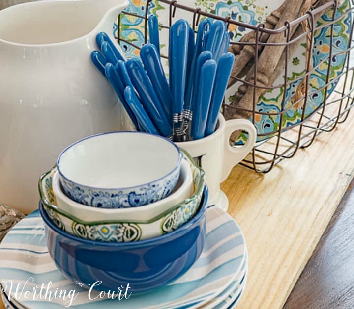 centerpiece with blue white and green dishes on a breadboard