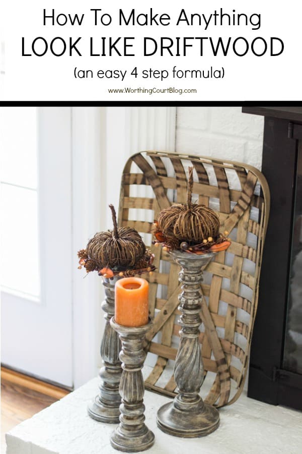 three gray candlesticks on a white brick hearth