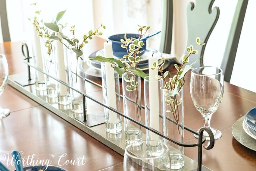 Simple summer centerpiece with cylindrical glass and greenery.