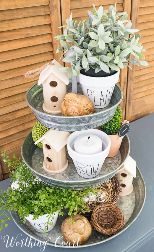 An aerial view of the tiered tray all decorated with the pots and birdhouses and bird nest.