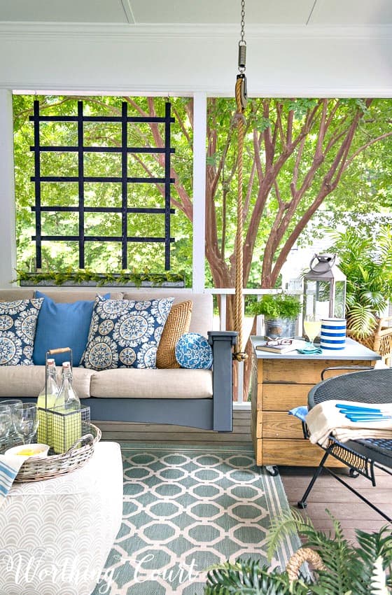 How To Make A Screened In Porch A Relaxing Oasis. A screened in porch turned into an oasis with the addition of a swinging sofa and pretty accessories. #screenporchdecorating #screenporchideas #screenporchdesign #screenporchrug #screenporchfurnture #screenporchmakeover #screenporchonabudget #swingingbedideas #outdoorrug