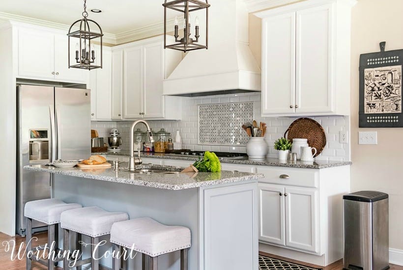 kitchen with white shaker cabinets and a gray island.