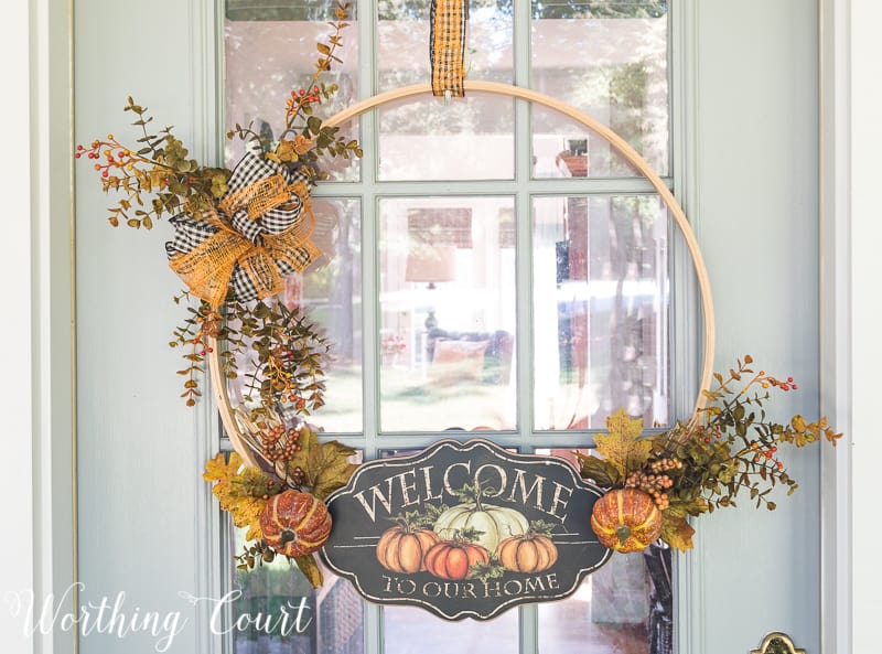 A large embroidery hoop decorated for fall and on the front door.