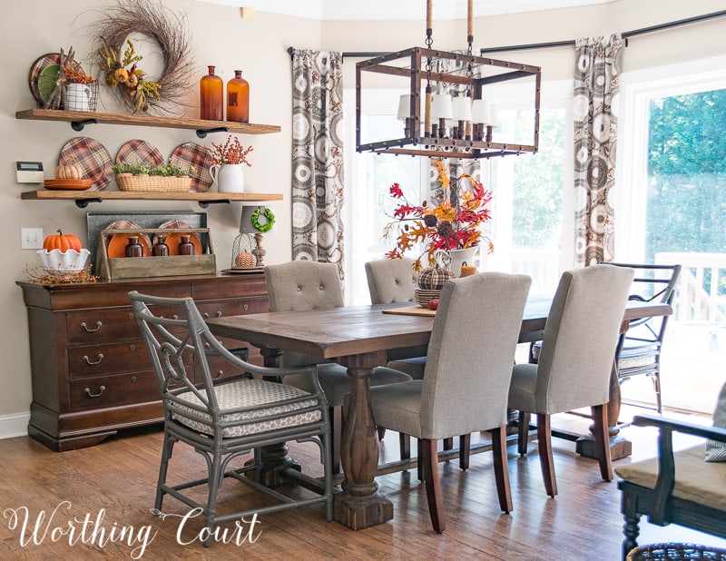 Breakfast room decorated for fall.   There is a fall centerpiece on the table, and the open shelving all decorated for fall.