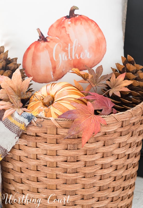 A basket filled with a pillow, pumpkin and pinecones makes an easy fall decoration || Worthing Court #falldecor #baskets