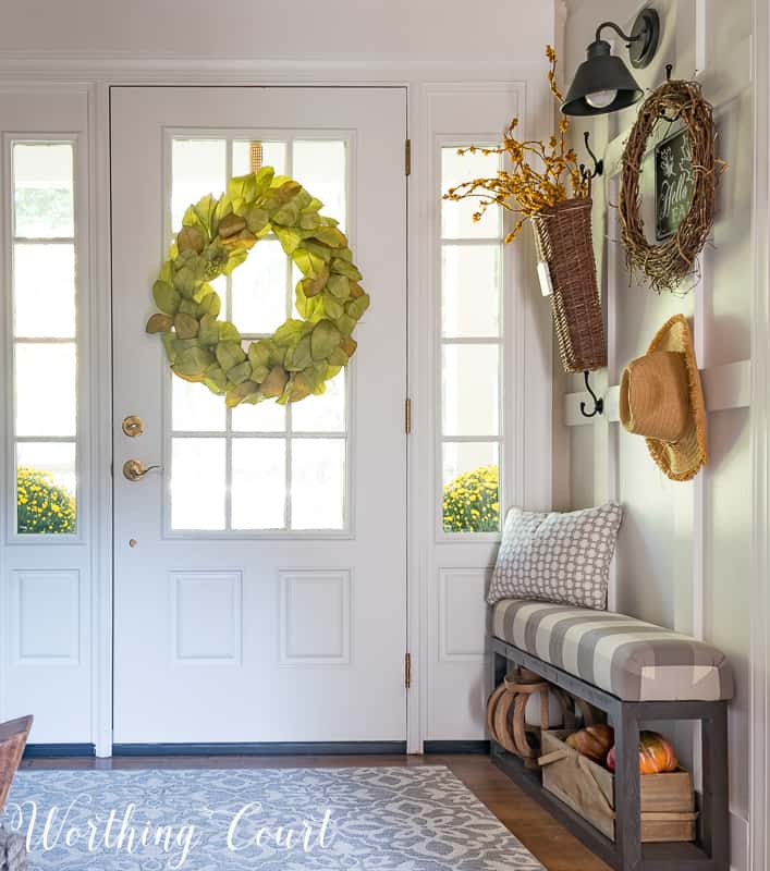 Magnolia wreath hanging on the inside of a glass front door