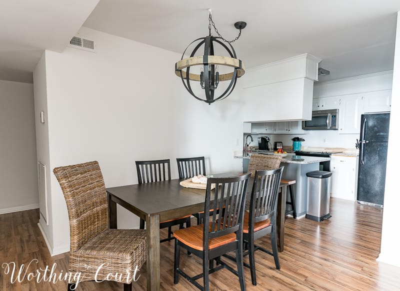 The walls painted white with a larger table in the dining room and the orb light hanging above it.