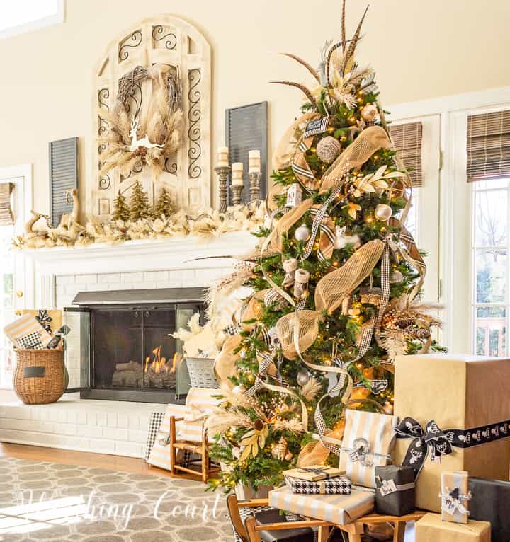 Christmas tree and fireplace decorated with neutral colors.