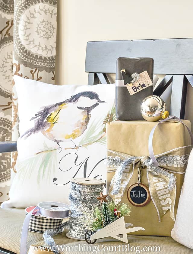 A chair filled with wrapped presents and ribbon for wrapping.