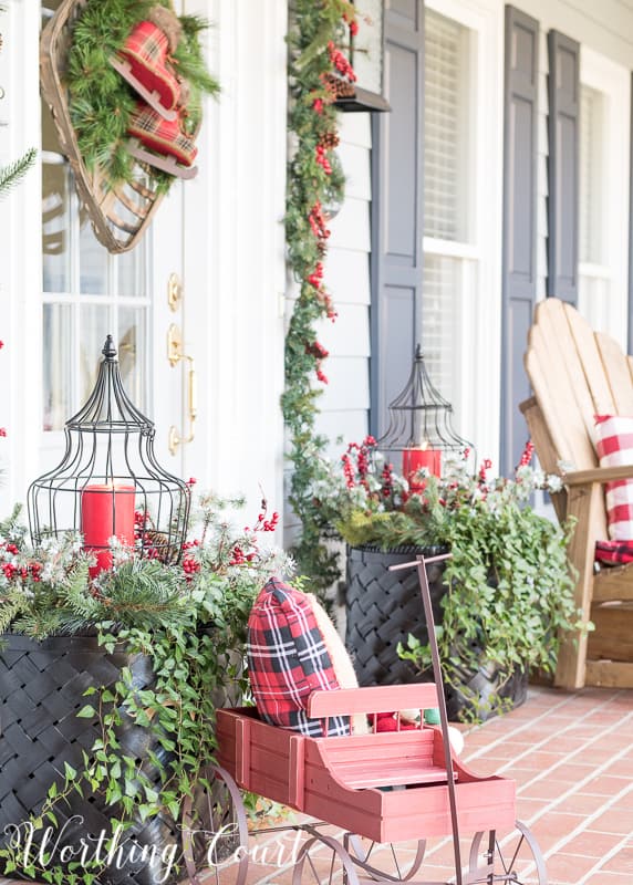 Outdoor Christmas planters with large red candles.