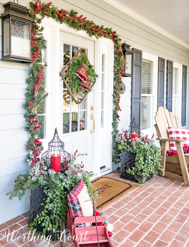 Front porch Christmas decor with a welcome mat.