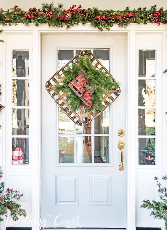 Christmas wreath created with a tobacco basket, greenery and a pair of plaid ice skates #christmas #christmaswreath #christmas decor.