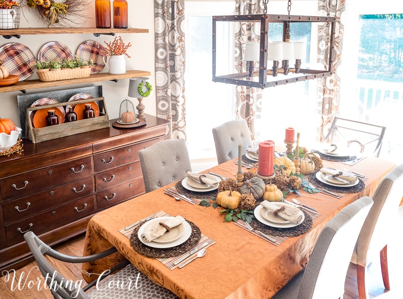 There is a farmhouse chandelier above the dining room table.