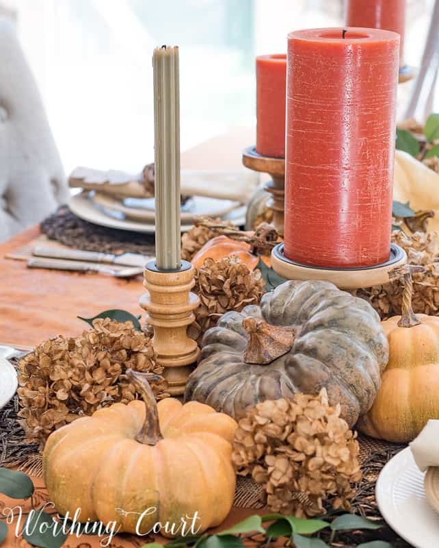 Small pumpkins and dried hydrangeas on the table.