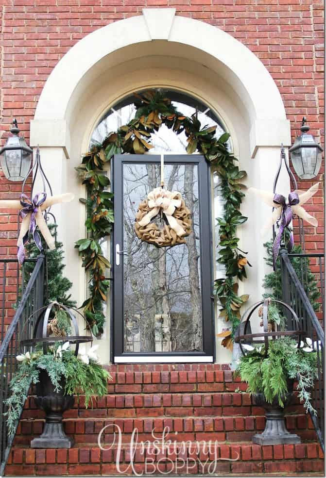 The front stoop decorated with holly and ivy on the porch.