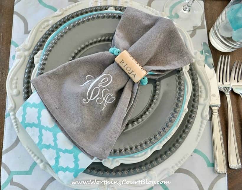 place setting with gray and white dishes and diy wine cork napkin rings