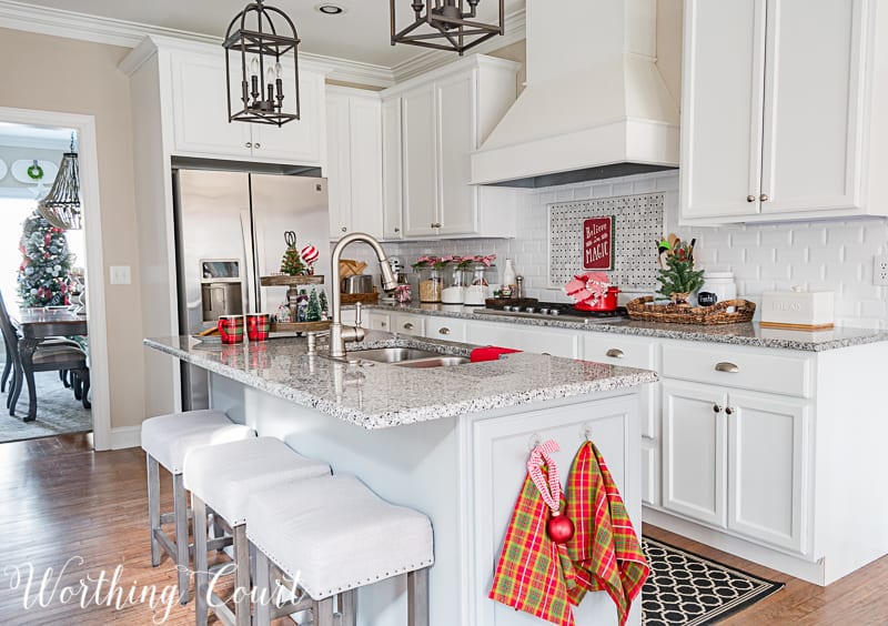 There are holiday tea towels hanging on the kitchen island.