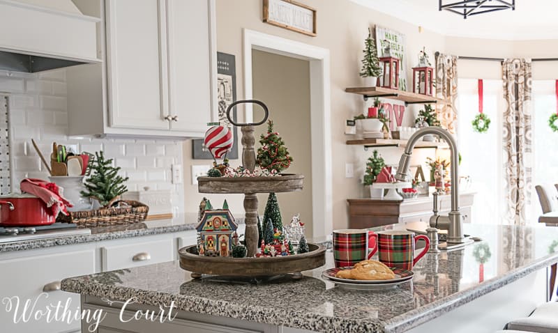 Two tiered wood tray filled with Christmas decorations on the kitchen island.