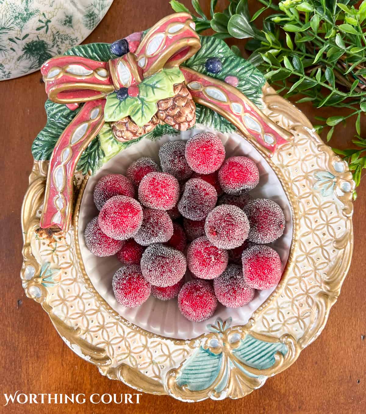 white and gold decorative Christmas bowl filled with faux red berries
