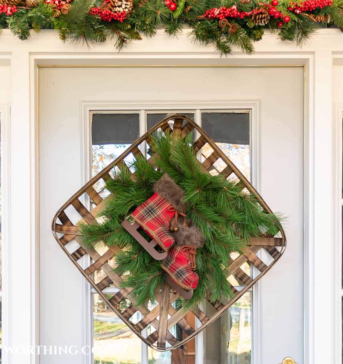 square tobacco basket and faux pine picks on a front door being used as a Christmas wreath