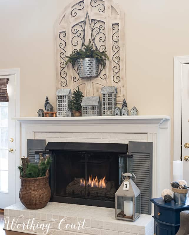 Painted brick fireplace, winter decorations, winter mantel and a small village on the mantel.