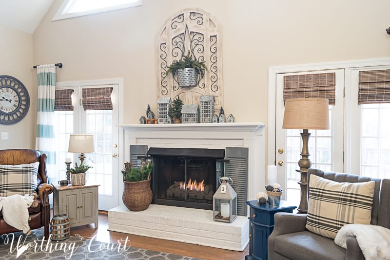 A fireplace in the sitting room with a leather armchair beside it.