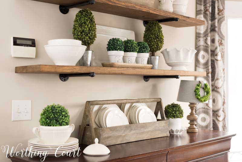 Spring decorating ideas for shelves with topiaries and white plates.