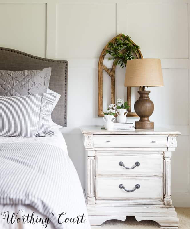 The whitewashed dresser nest to the bed.