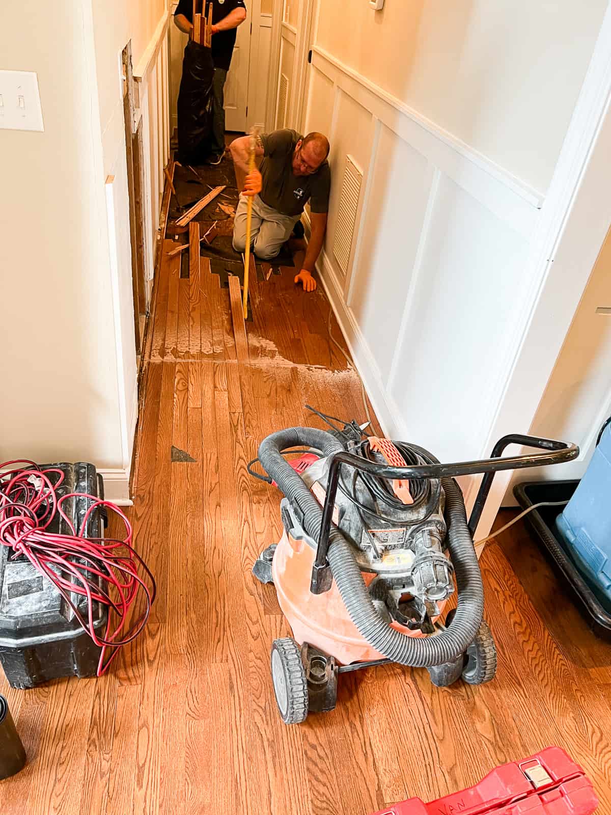 men working in a hallway where there was a waterleak