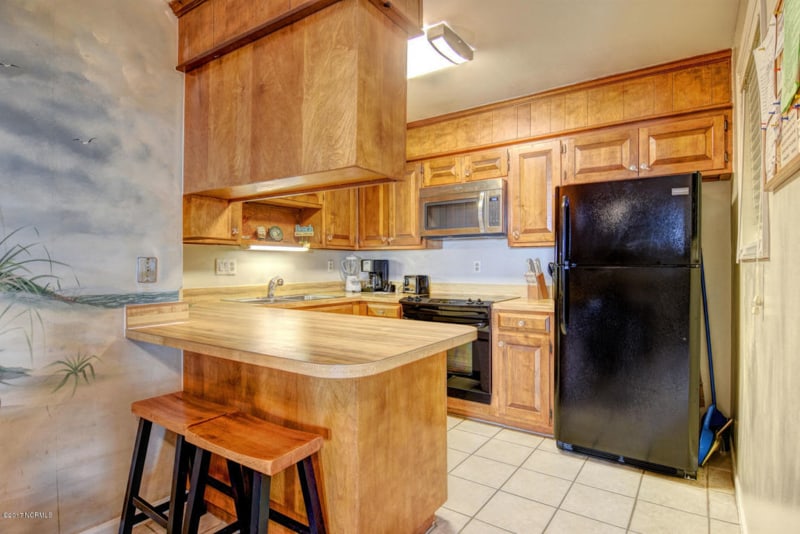 Small galley kitchen before makeover, with dark wood cabinets.