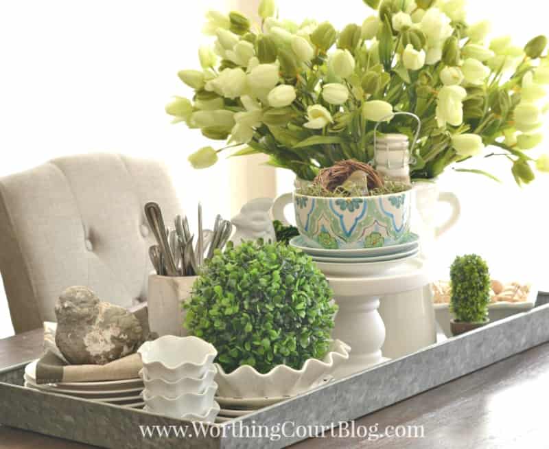 Spring centerpiece with tulips, bird nests and white dishes #centerpiece #spring #springdecor