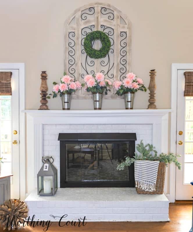 Fireplace decorated for spring with pink peonies.