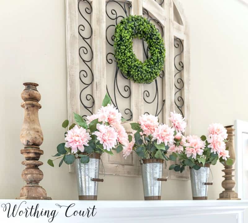 Trio of pink peonies on a fireplace mantel.