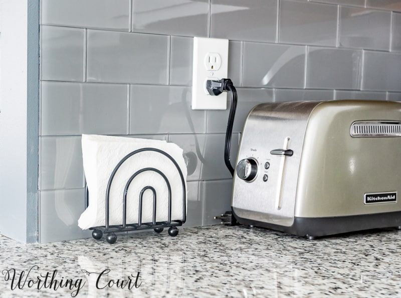 There is a toaster plugged in with napkins beside it.