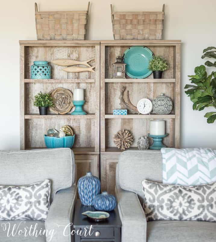 Gray bookcases with baskets on top and decorative accessories.