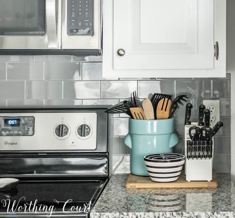 A light blue pottery with utensils in it.