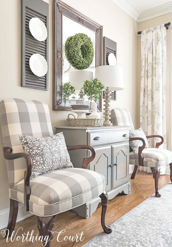 Farmhouse dining room with Martha Washington side chairs upholstered with buffalo check fabric and gray accent chest. #diningroomdecoratingideas #farmhousedecor #buffalocheck #neutralcolors 