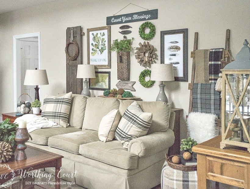 Family room sofa with rustic farmhouse gallery wall in neutral colors with touches of artificial greenery. #familyroomdecor #livingroomdecor #farmhousedecor #gallerywall #decoratingideas #vintagedecor 