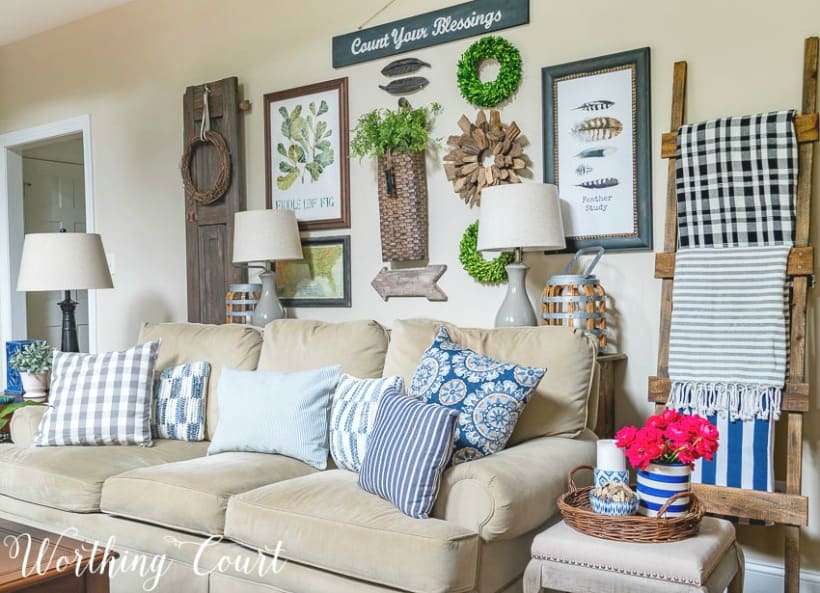 Gallery wall above the sofa that is filled with throw pillows.