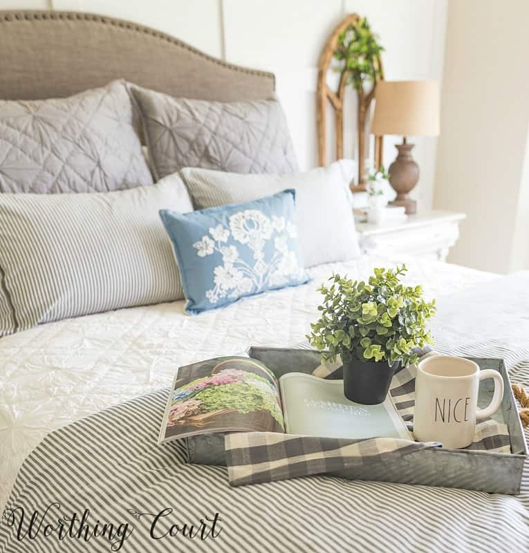 Farmhouse style bedroom with a galvanized tray on the bed.