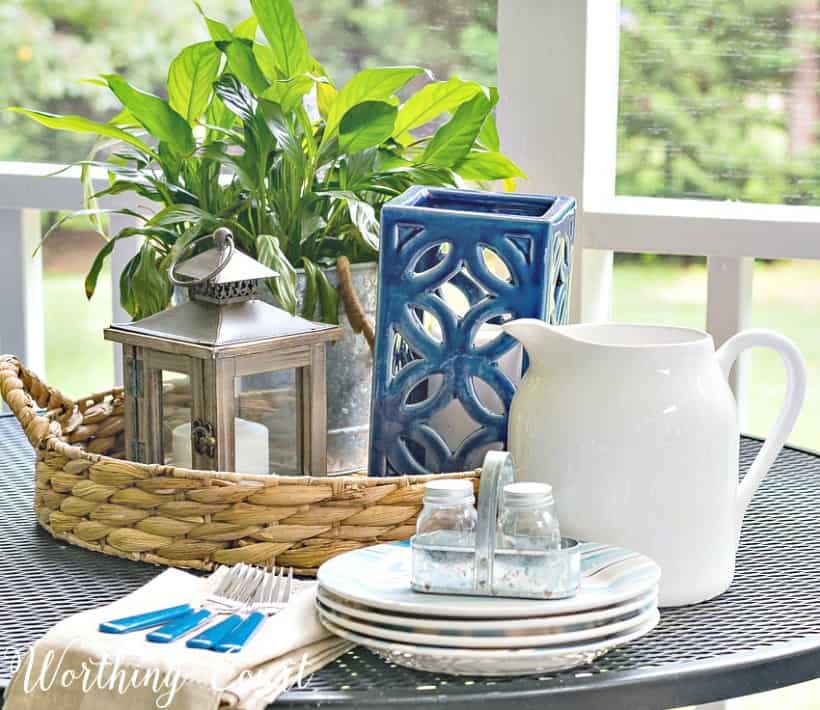 Outdoor table centerpiece with a white pitcher and plates.