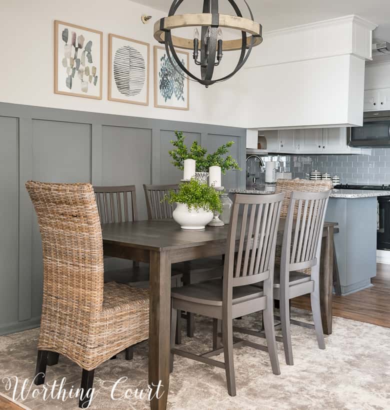 white home accents used on a dark wood dining table with faux greenery against a gray board and batten accent wall